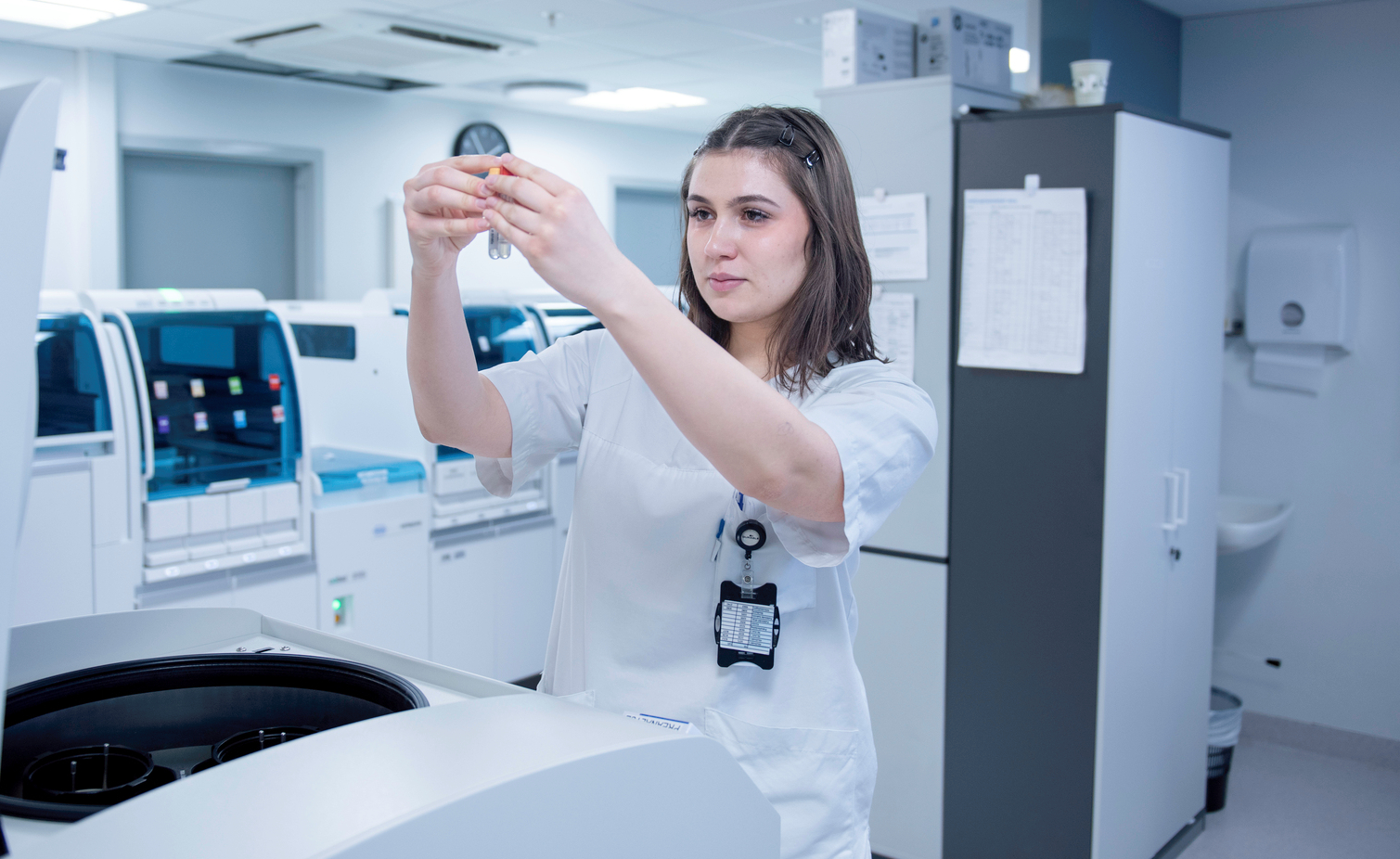 A bioengineer examines blood samples in a laboratory with advanced analysis equipment.