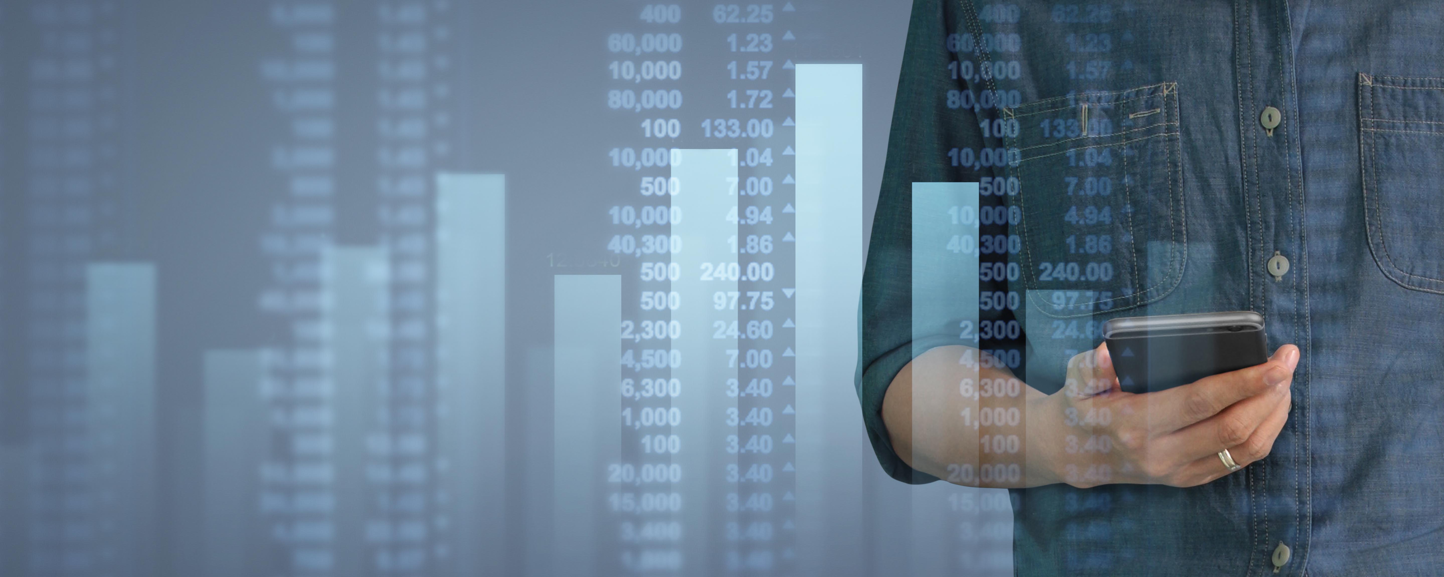 A male office worker looks at salary statistics on his mobile phone. Shows the importance of comparing salaries during salary negotiations.
