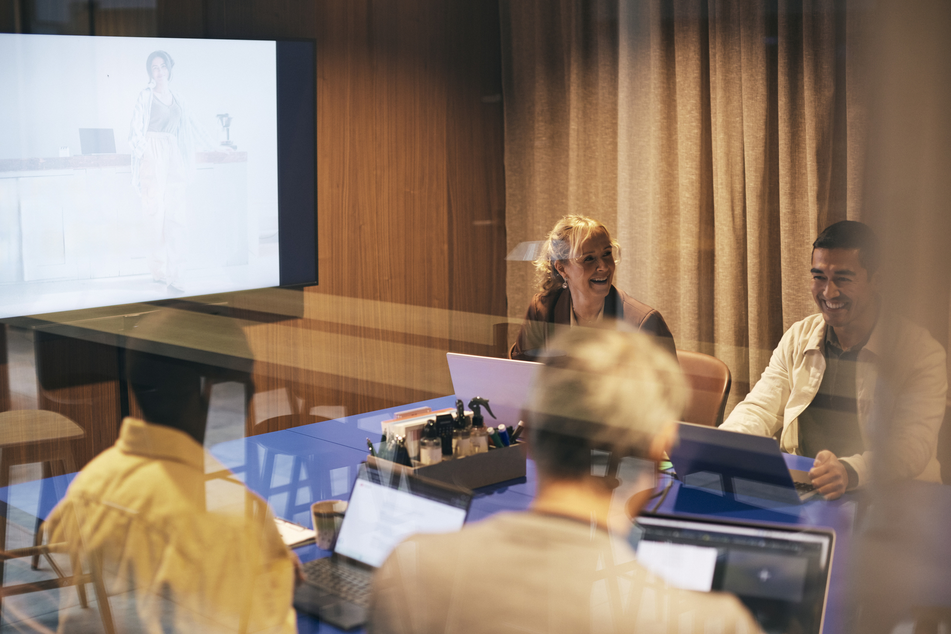 A board meeting with engaged participants discussing in front of a presentation screen symbolizes strategic cooperation and decision-making processes around collective agreements.