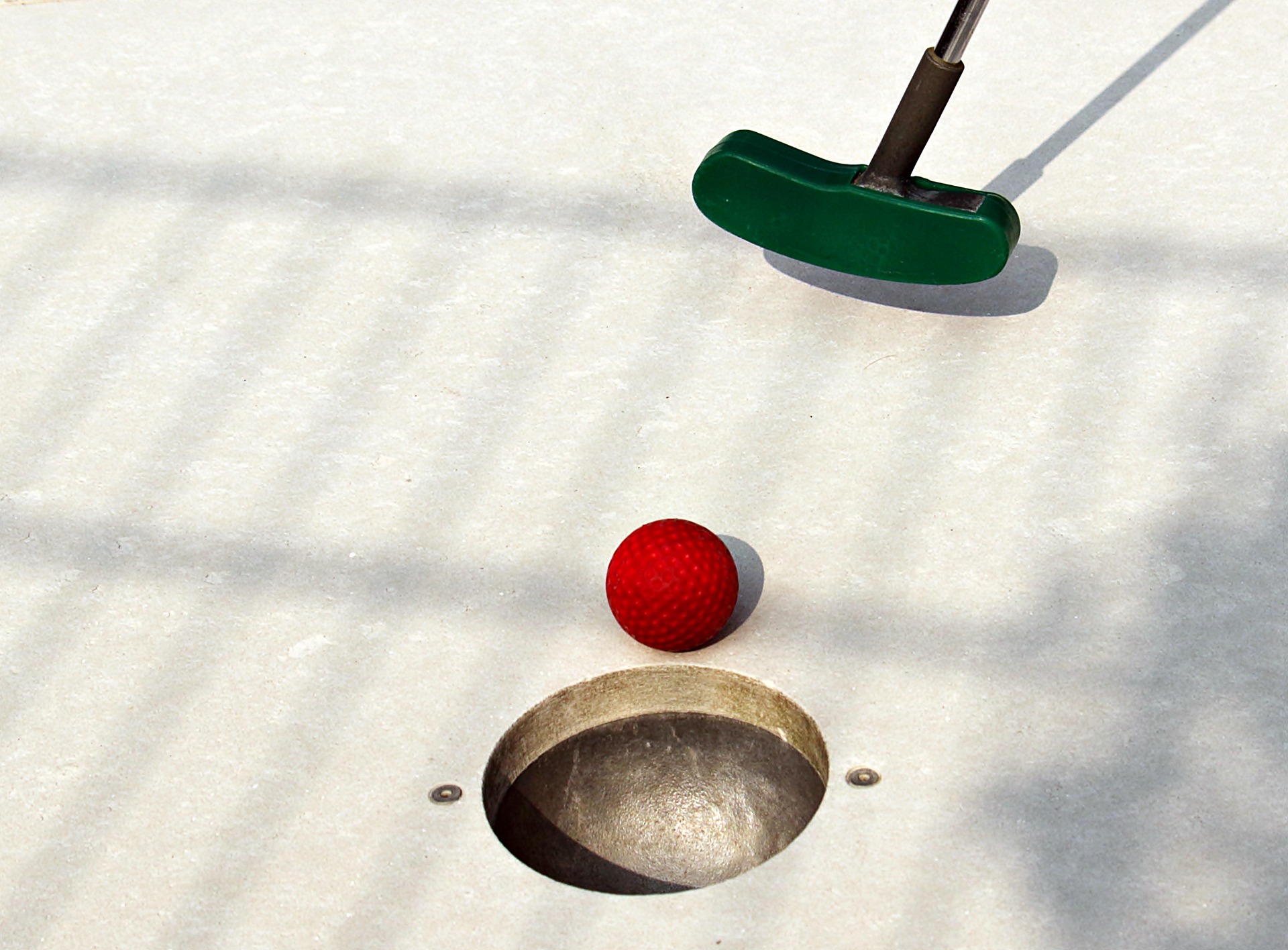 Minigolfkølle og ball på en bane