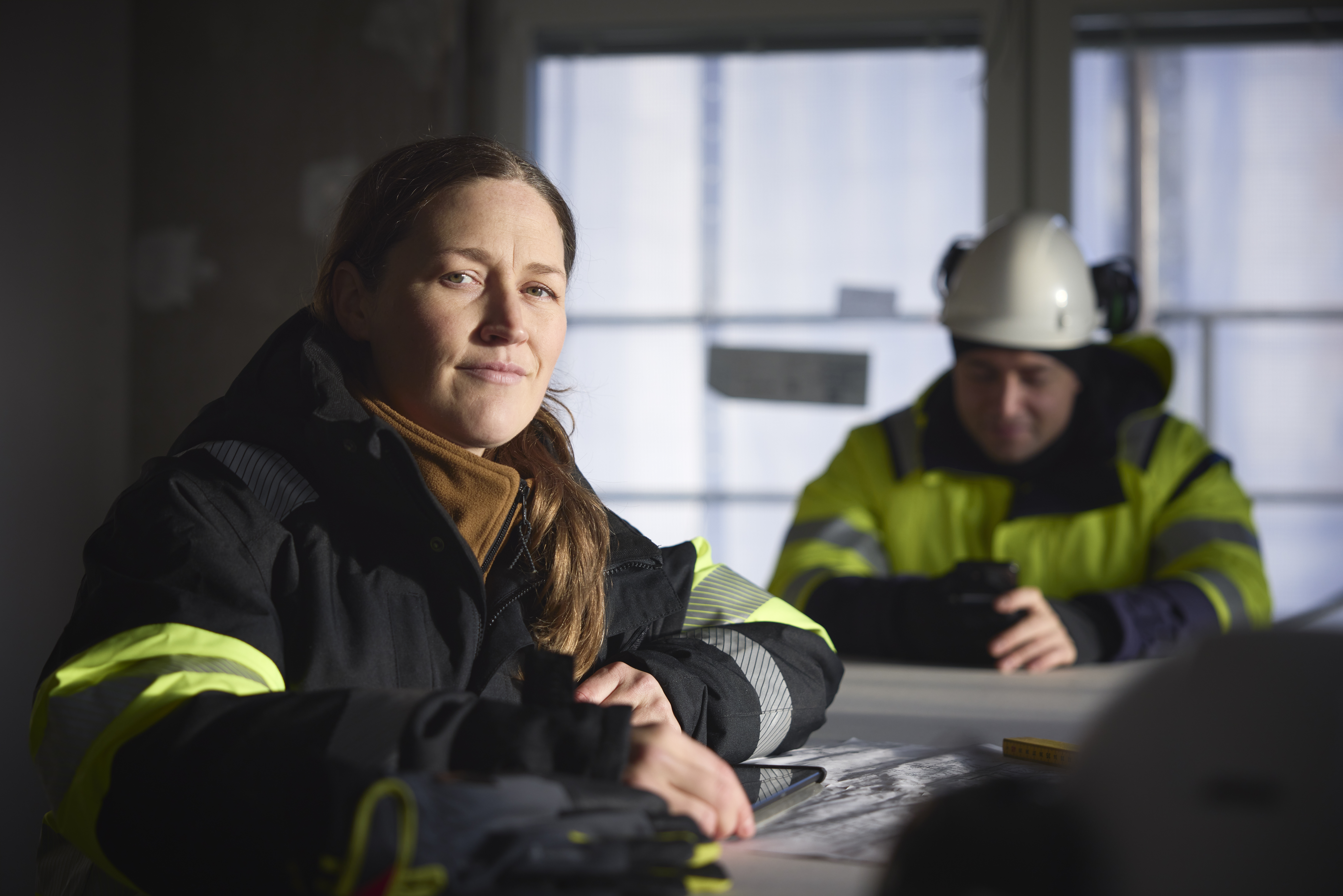 Dame og mann i arbeidsklær. Damen kikker inn i kamera. Getty images
