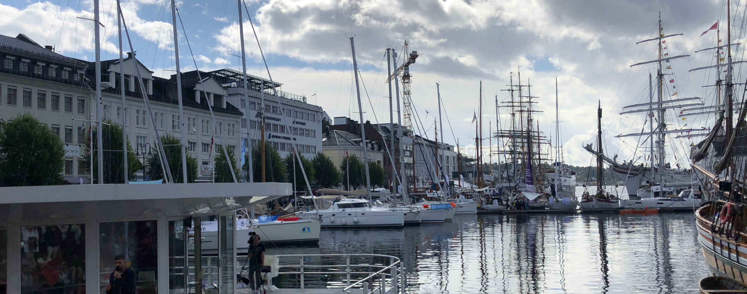 The picture shows Pollen in Arendal during Arendalsuka, with sailboats and people along the quay.