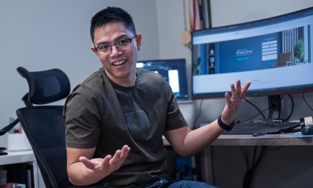 John-John som veiver med armene foran en dataskjerm. 