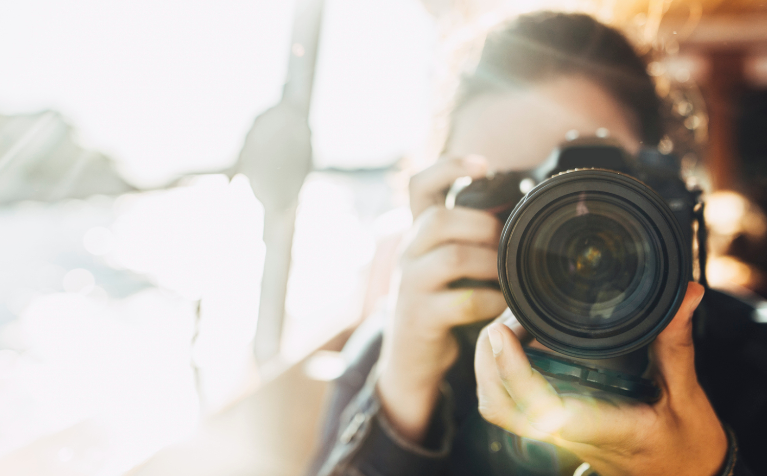 Woman with a camera in the foreground. The background is unclear.