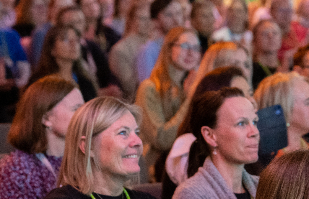 A group of cheerful people sitting in a congress hall.