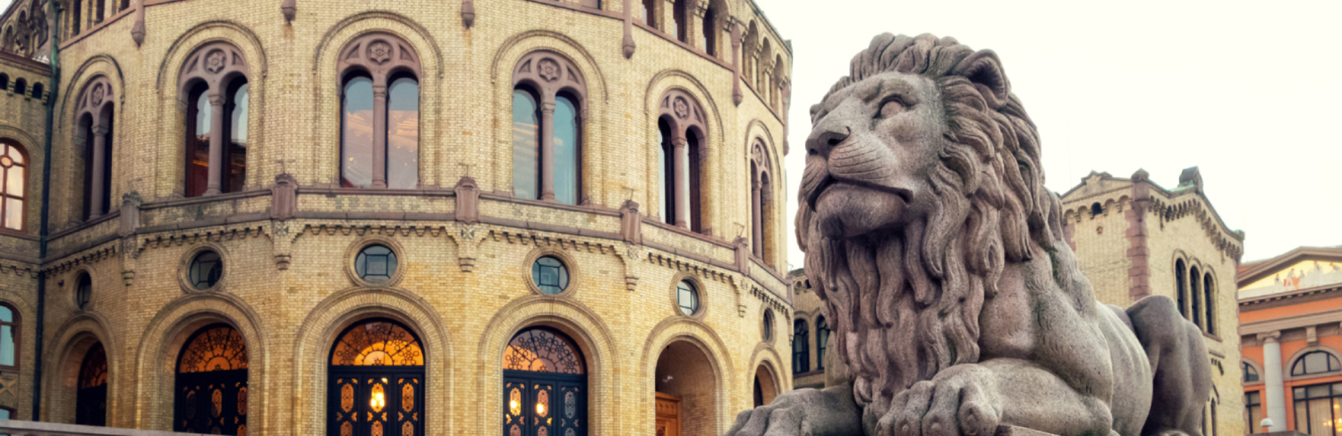 Section of the Storting building, with one of the Storting lions in the foreground.