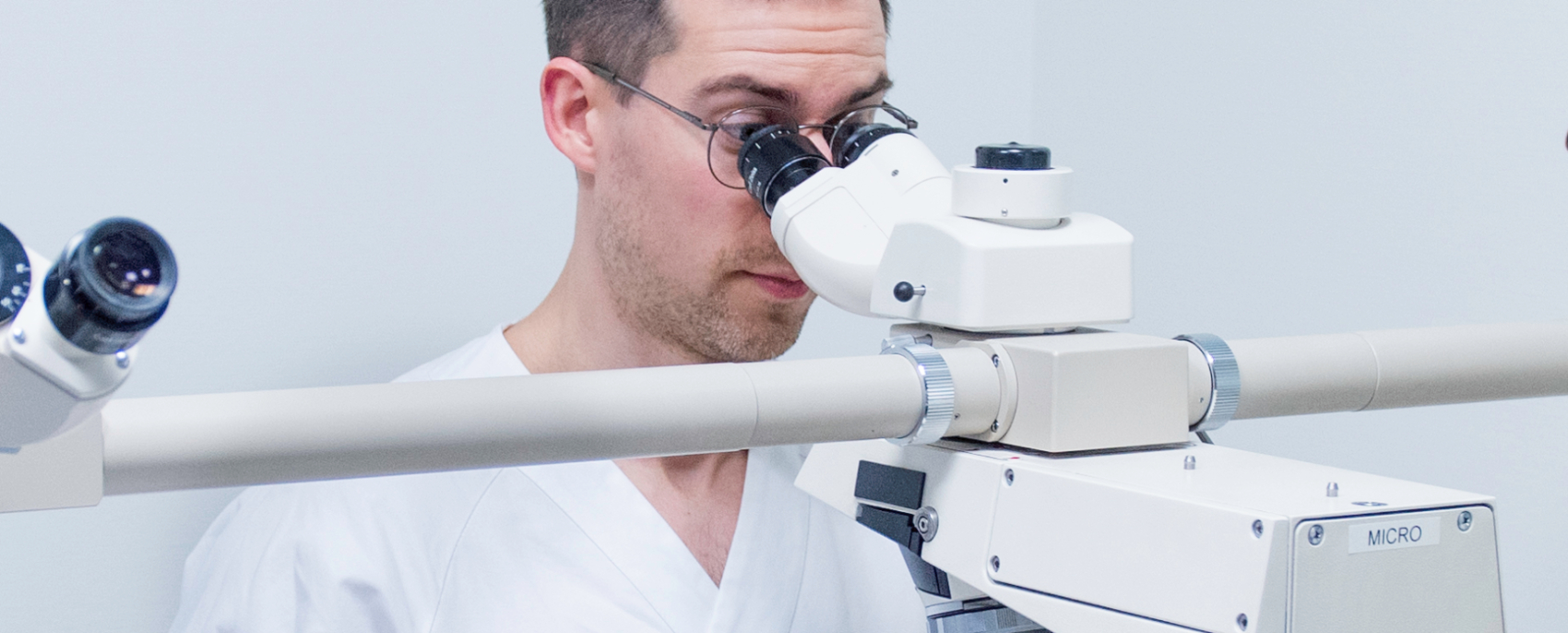The picture shows a bioengineer in a laboratory environment conducting a microscopic examination.