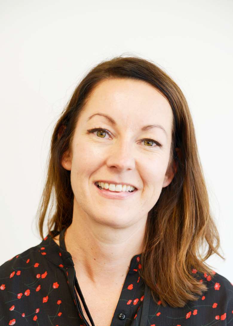 Portrait of smiling woman with long dark hair.