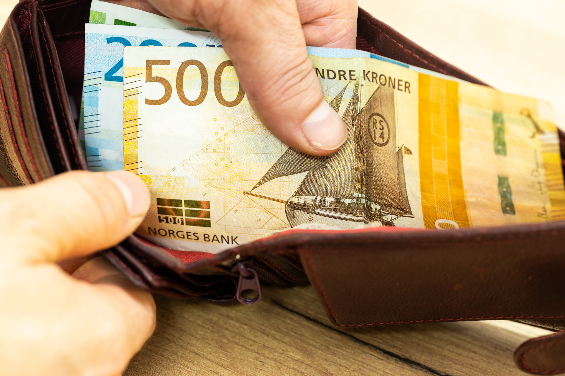 Åpen lommebok med norske kroner