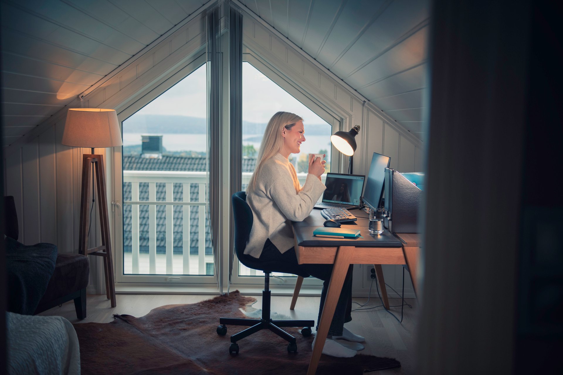 Female engineer in a home office with an ergonomic workplace in a bright attic room.