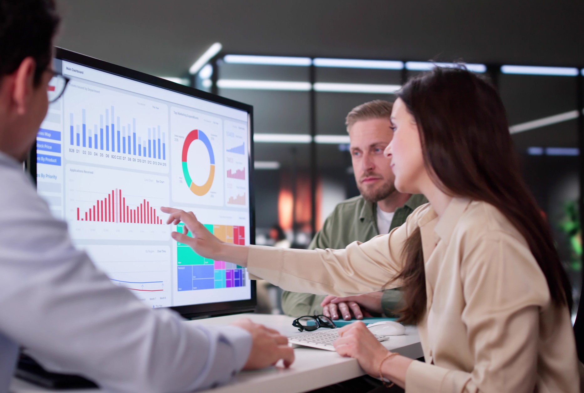 En kvinne og en mann analyserer data i et dashboard