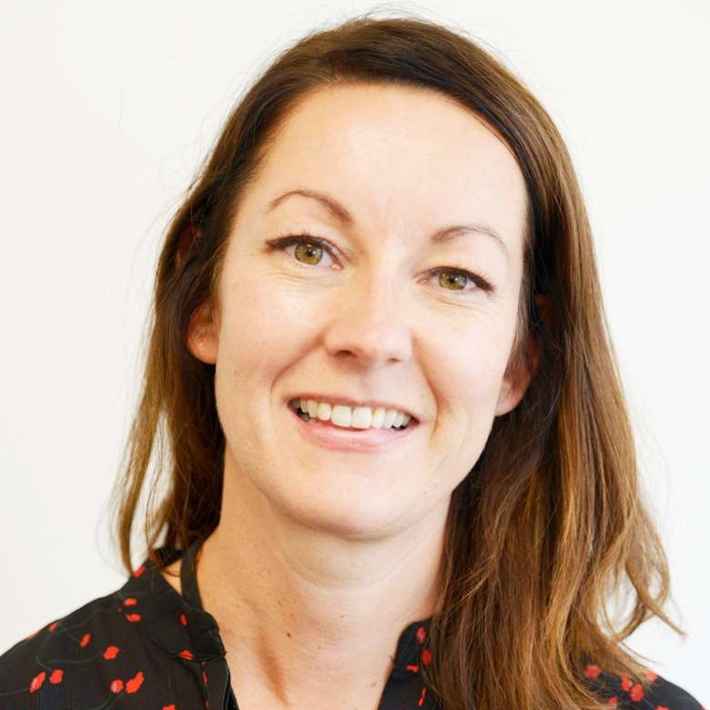 Portrett av smilende kvinne med langt mørkt hår.