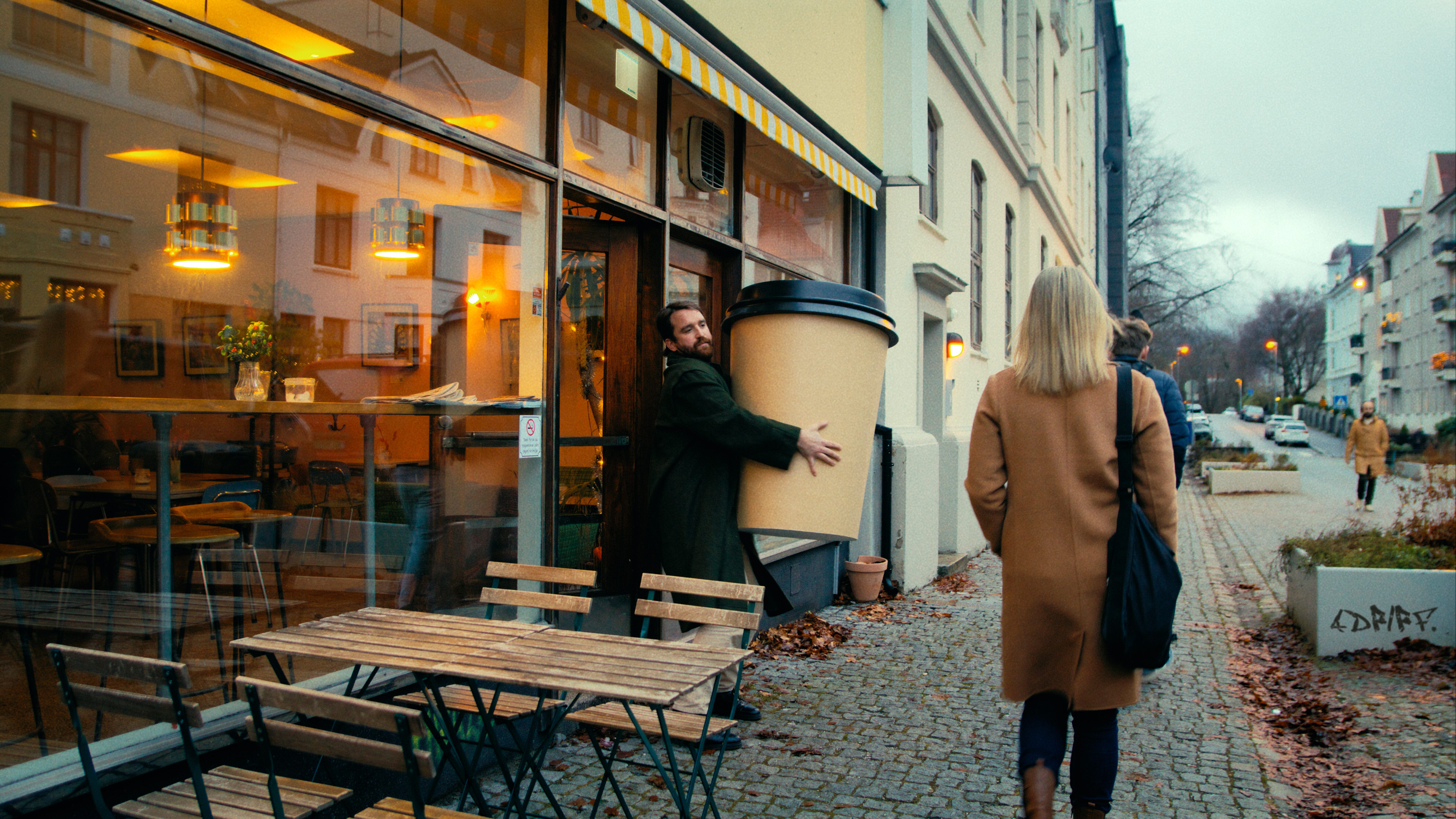 En mann bærer på en enorm kopp med kaffe. Reklame for NextGenTel - du får mye mer enn du tror