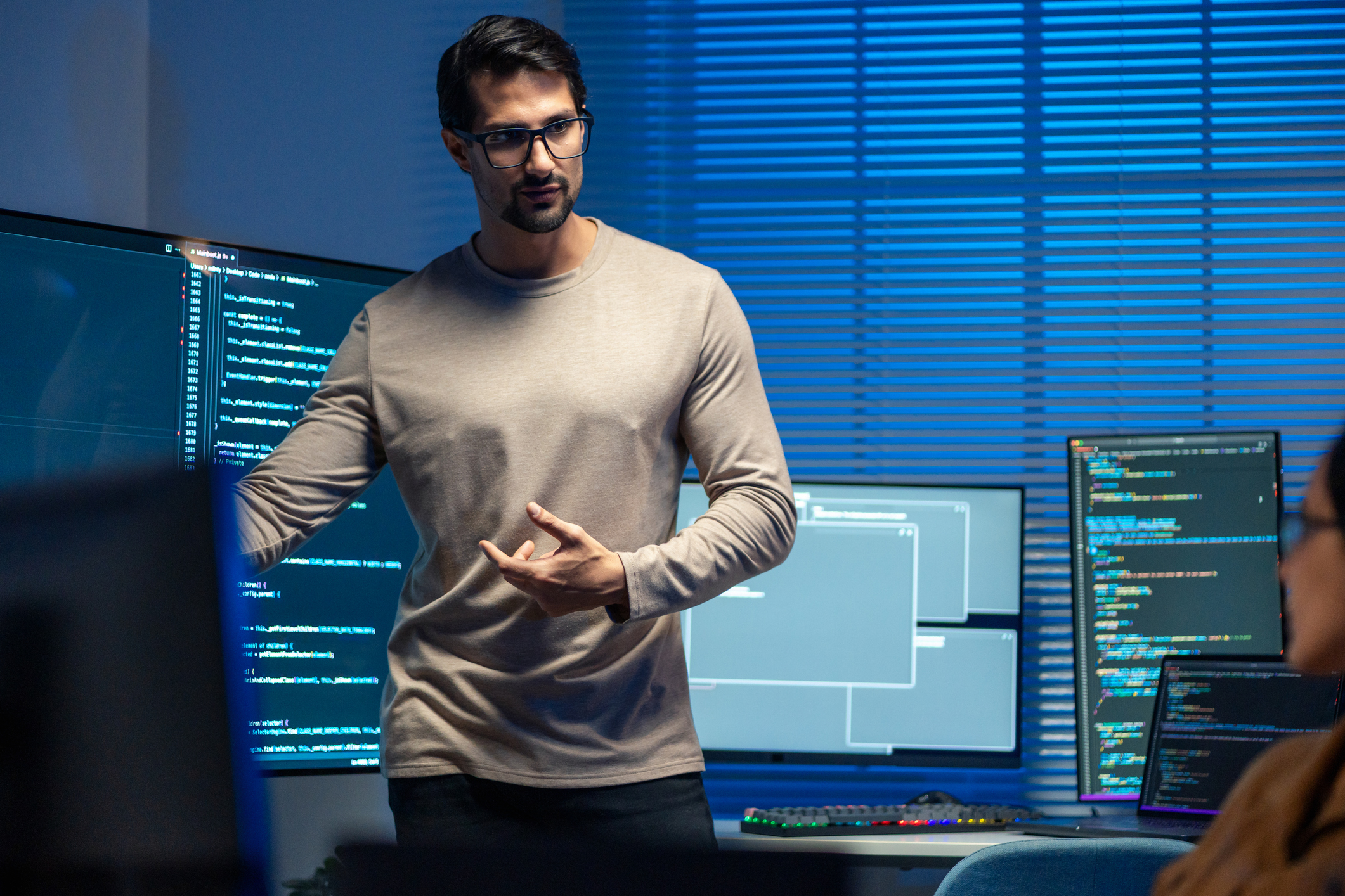 Mann peker på en dataskjerm med JavaScript koding