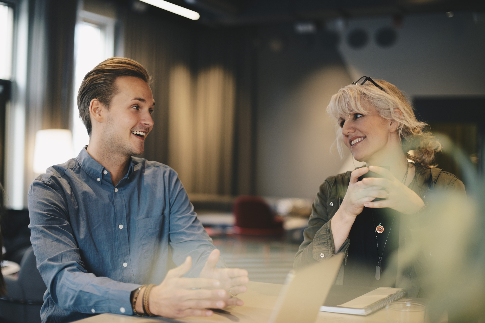Two colleagues, a man and a woman, in an engaged conversation about collective agreements and working conditions. Illustrative photo for article on the importance of collective agreements and the role of union representatives.