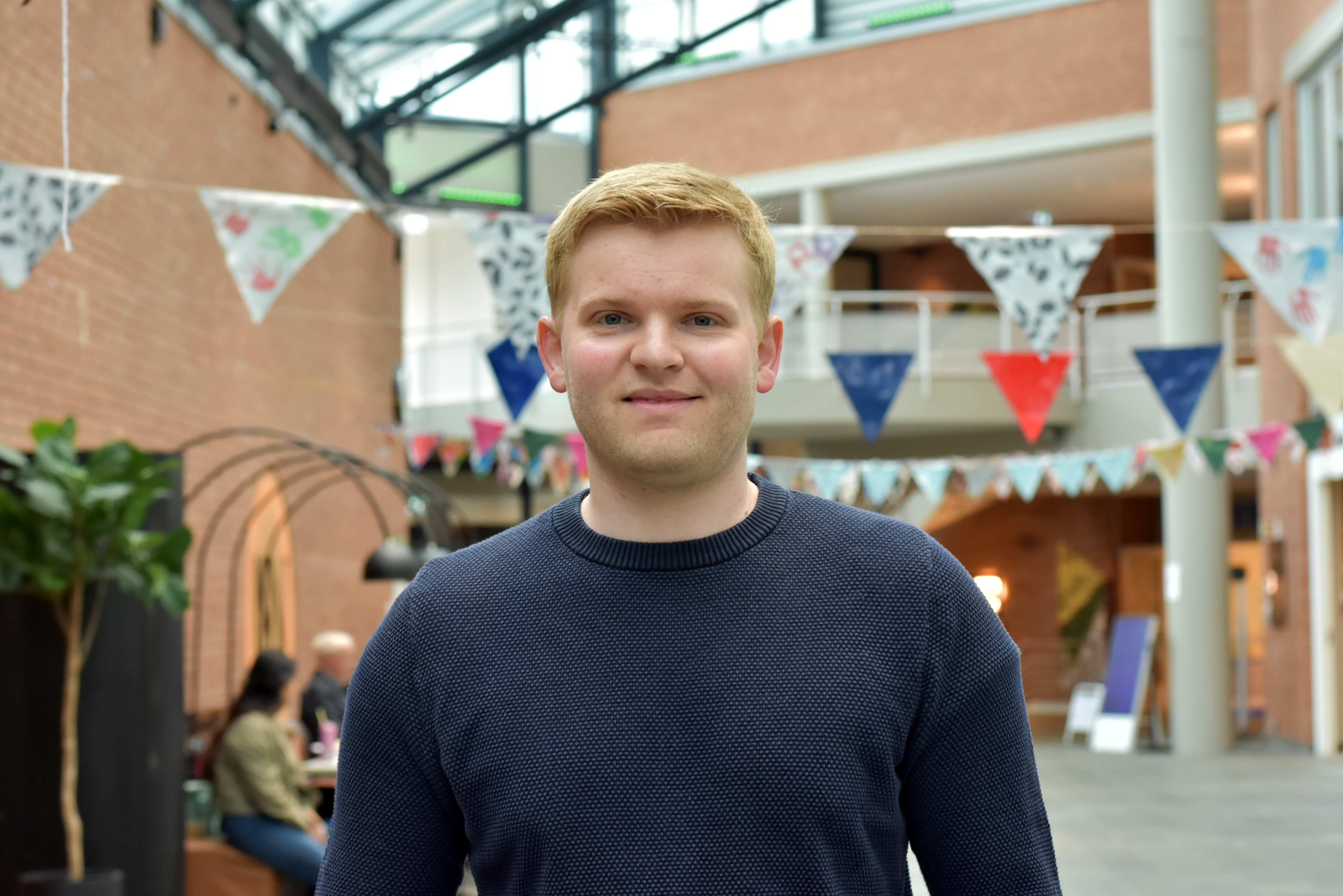 Eivind står i foaje på USN Porsgrunn.
