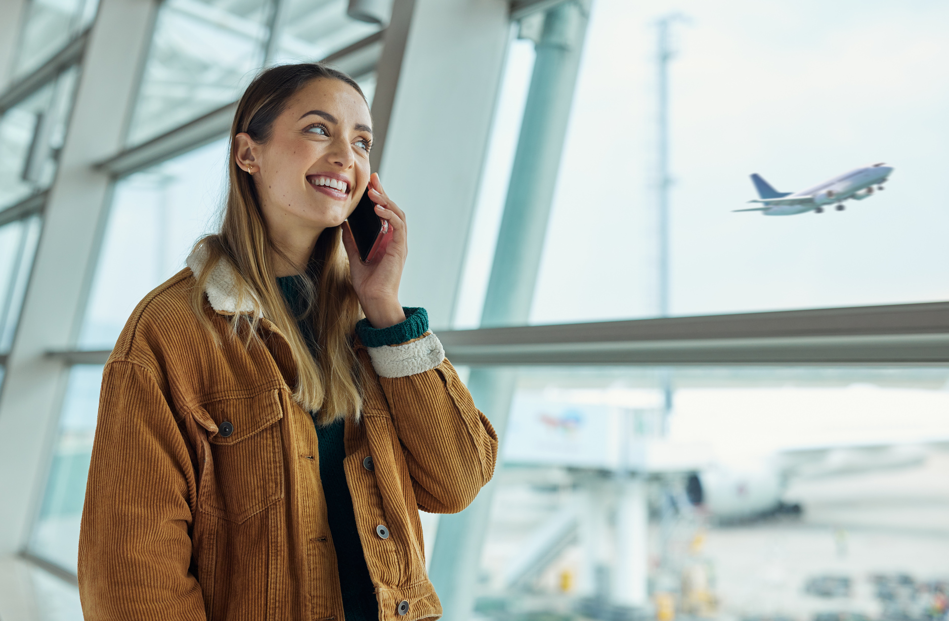 A woman talks on the phone in a modern environment, symbolizing the importance of communication and negotiation in working life and when entering into collective agreements.
