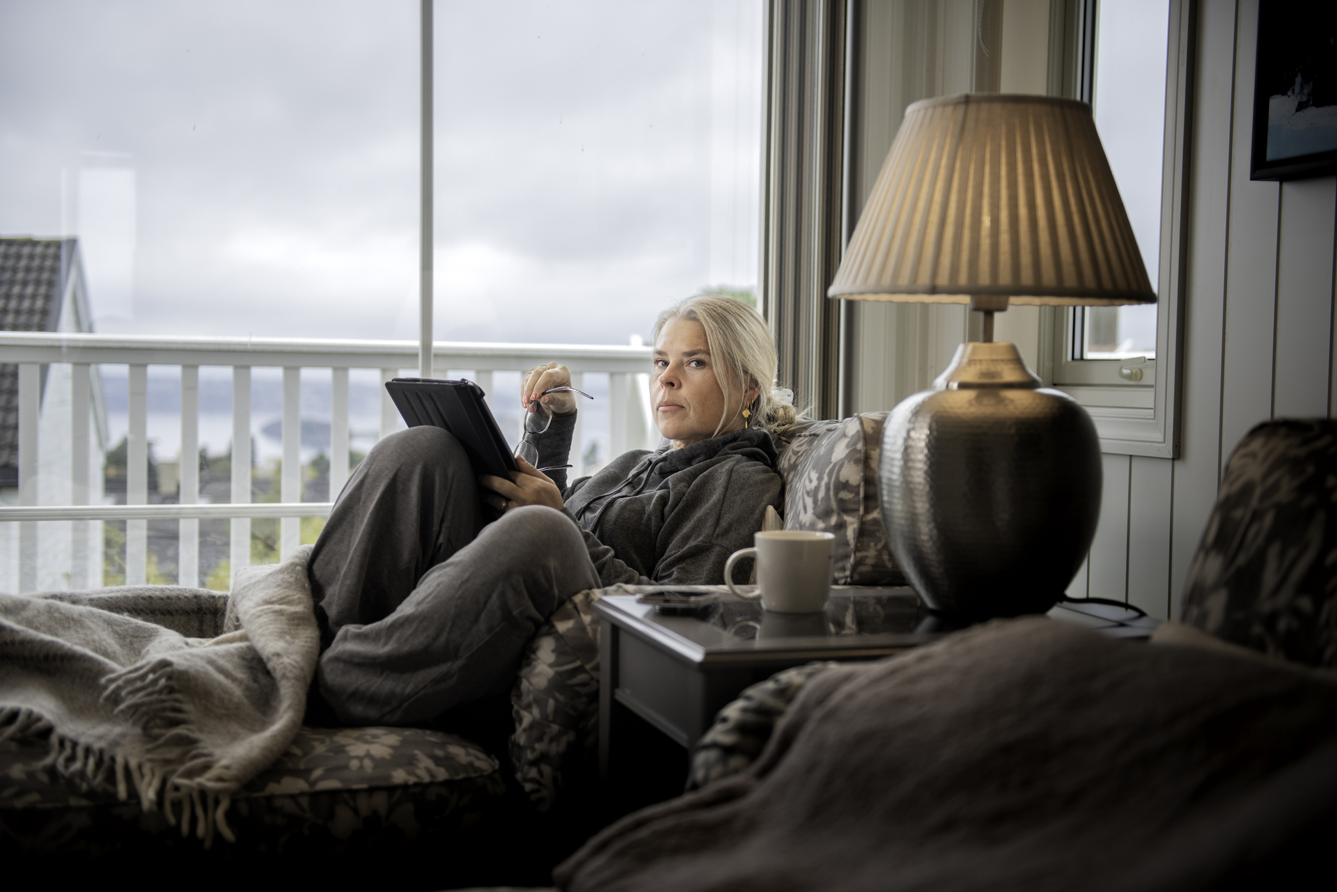 En kvinne sitter i sofaen hjemme Foto: Luca Kleve-Ruud