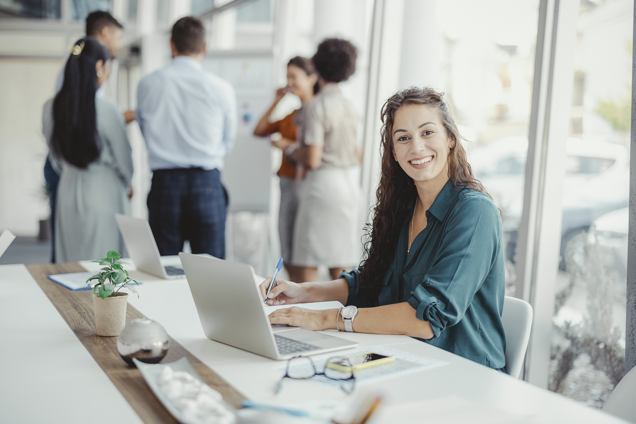 Kvinne i en prosjektgruppe som smiler.