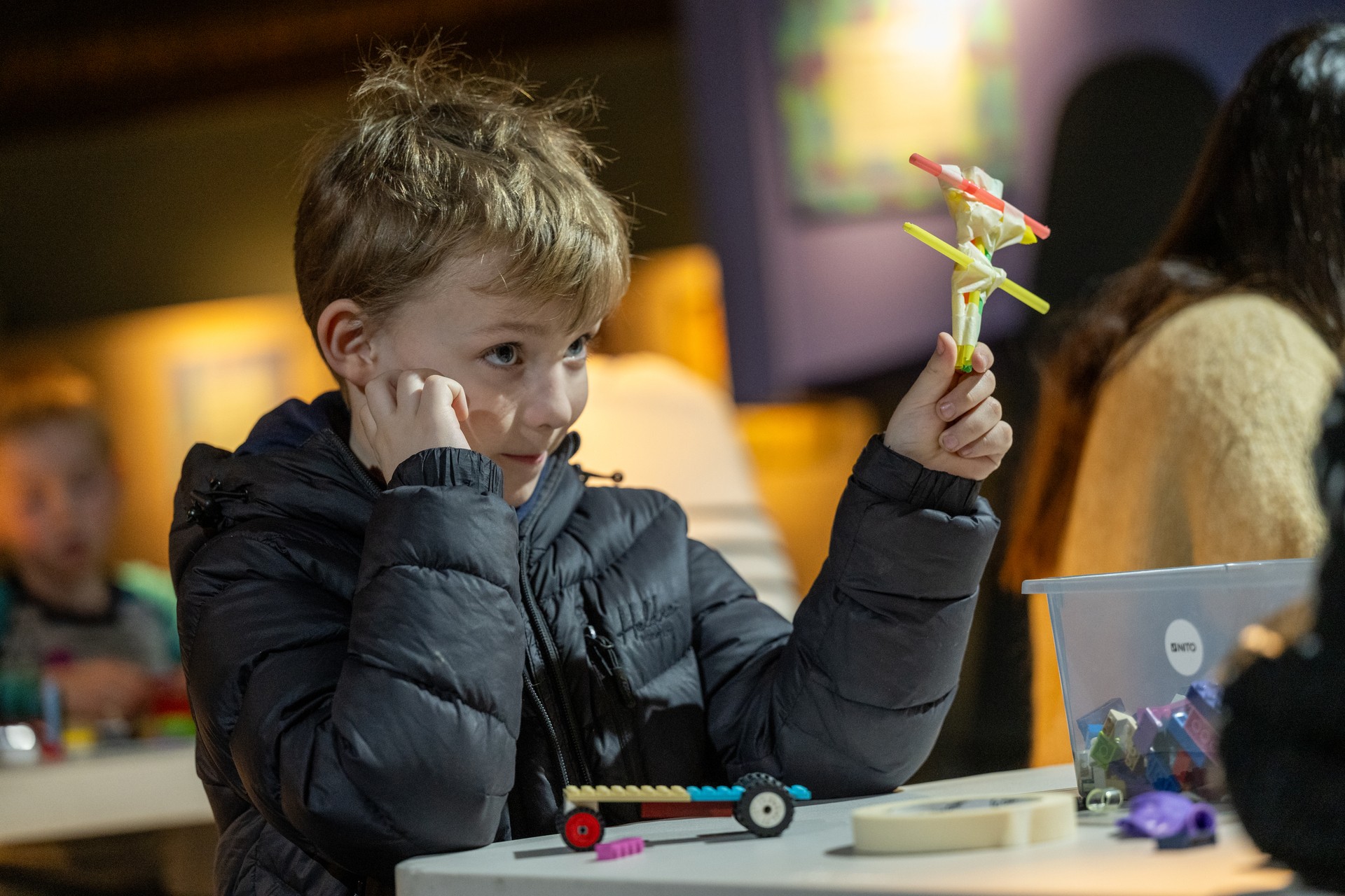 Gutt sitter å leker med lego