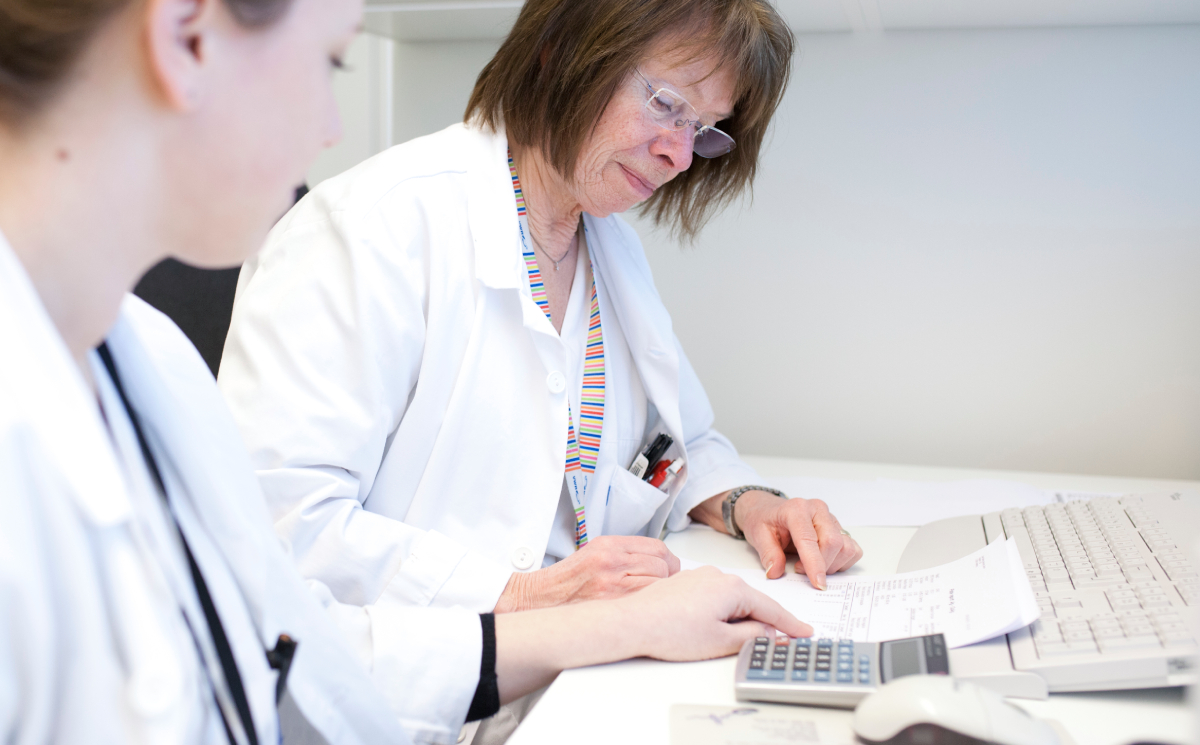 Two female bioengineers in an office environment. One guides or explains something to the other.