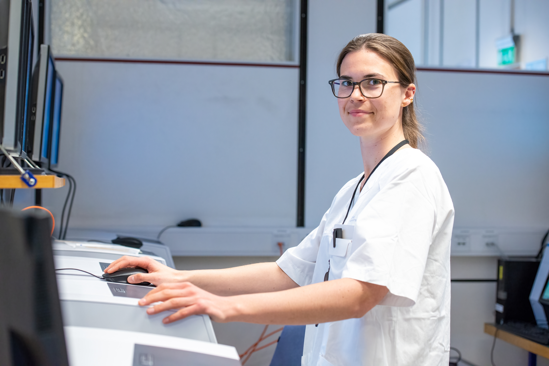 Biomedical laboratory technician in white lab coat works with advanced laboratory equipment - illustrates biomedical laboratory technician salary and working conditions in Norway