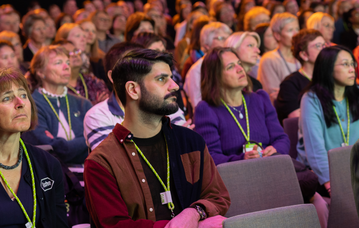 The picture shows congress participants sitting in a hall. The atmosphere is engaged and positive.