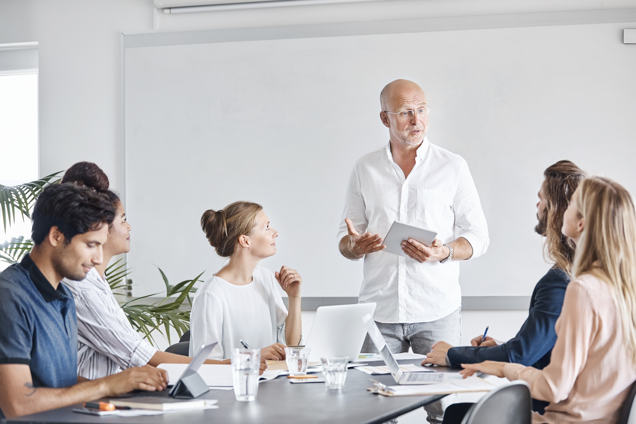 Et team samarbeider rundt et møtebord i et lyst, moderne kontor