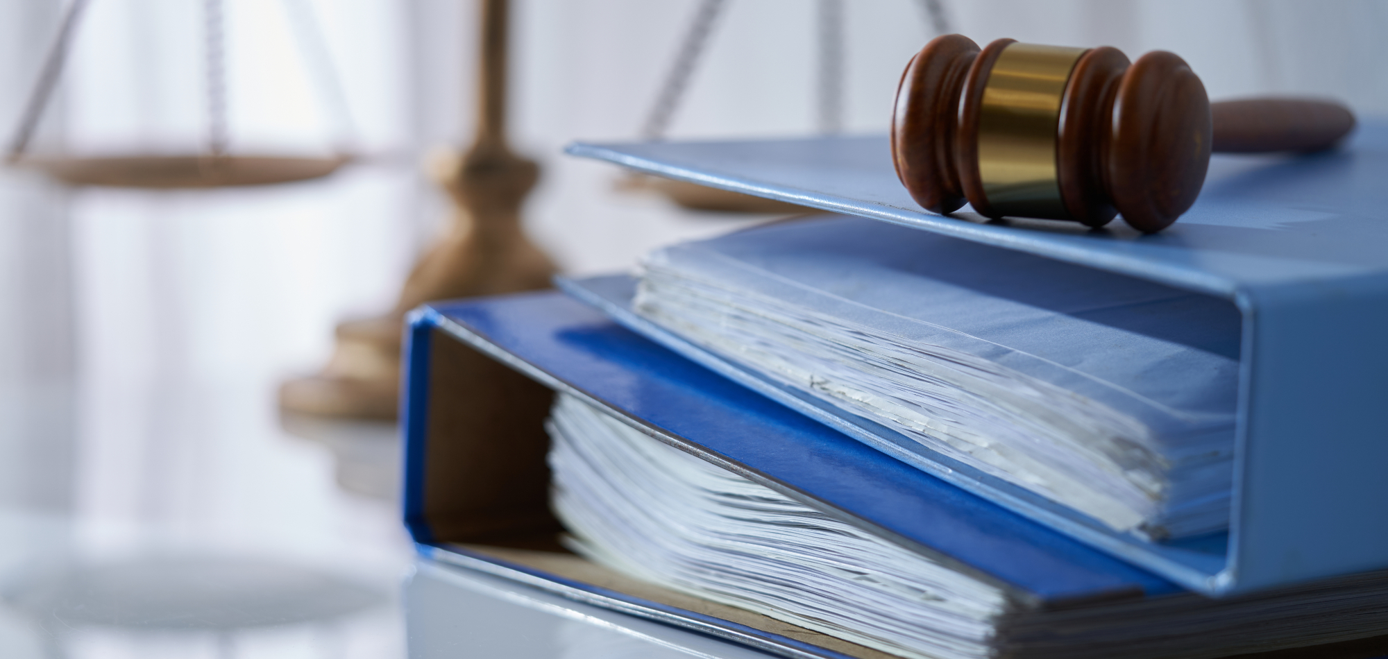 Sakspermer fulle av papirer liggende på et bord, med en dommeklubbe liggende oppå.