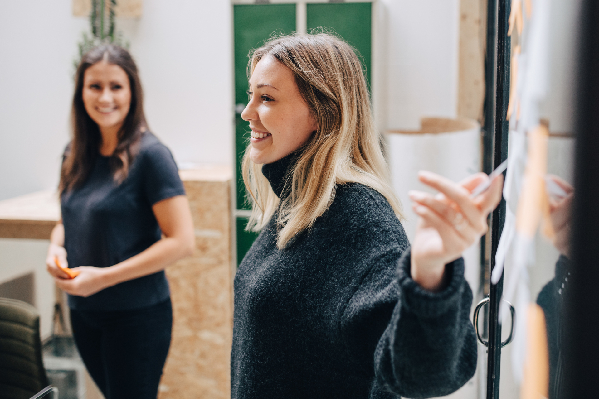 >Smiling businesswoman explains strategy for salary negotiation with her colleagues. Shows the importance of cooperation in wage negotiations.