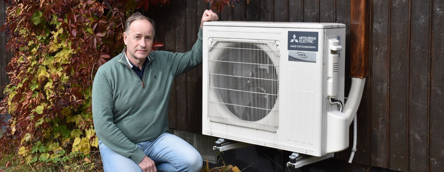 Bjørn Østmoe out in front of the house with his heat pump.