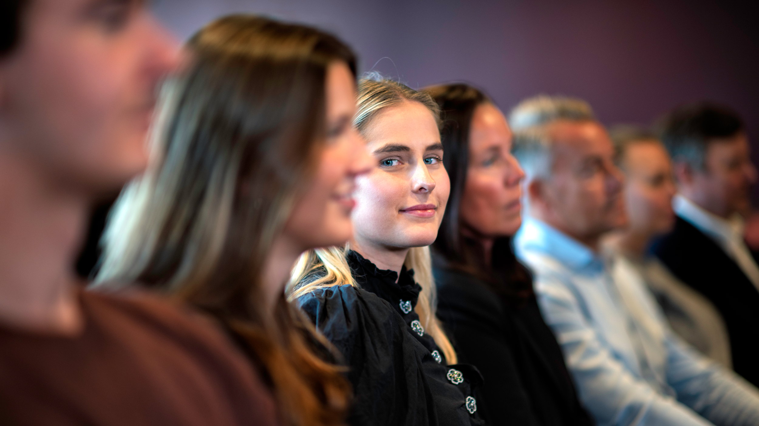 Members and union representatives sit together and engaged during a meeting about the collective agreement.