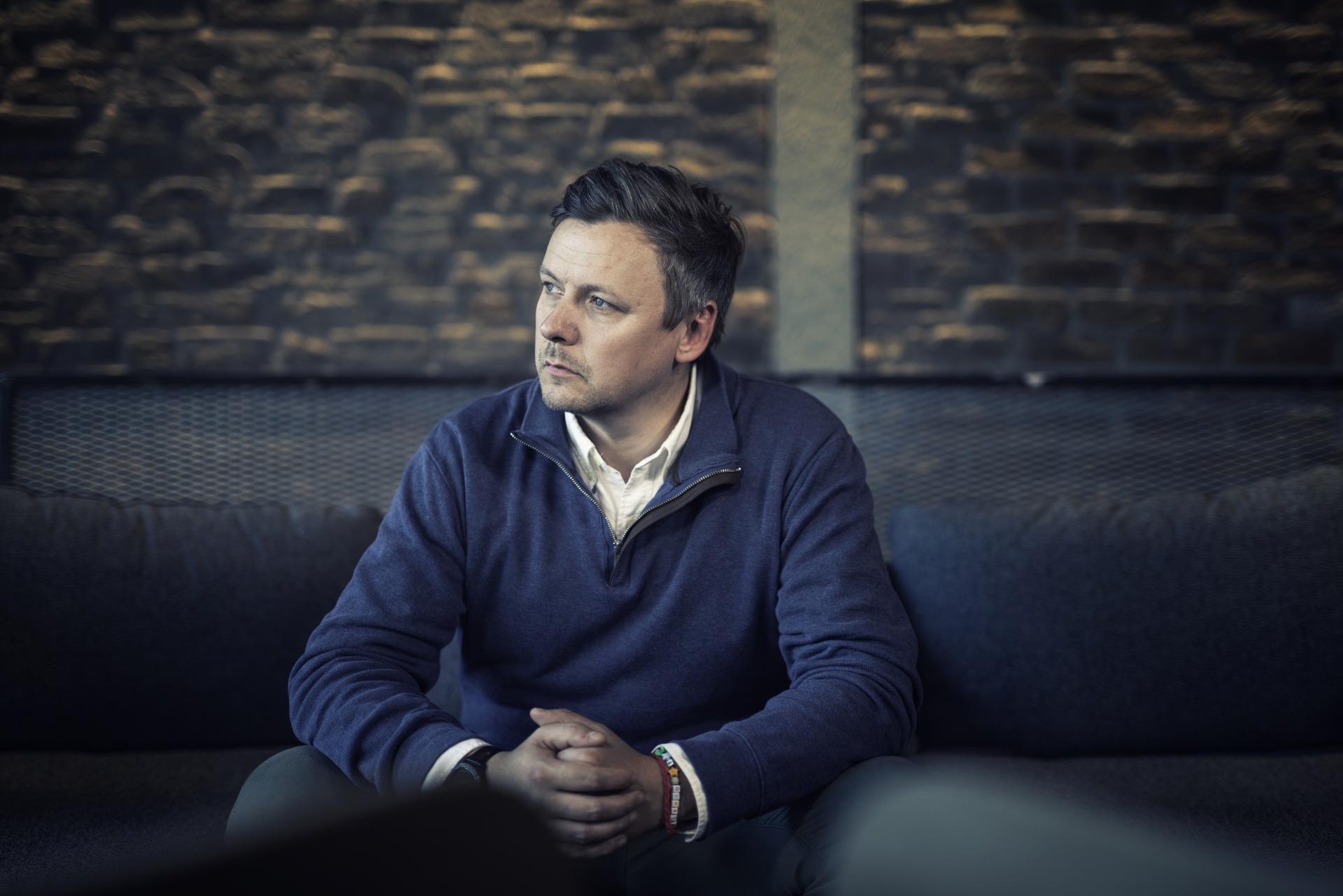 Man sitting on sofa with worried expression