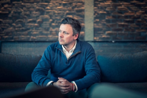 Man sitting on sofa with worried expression
