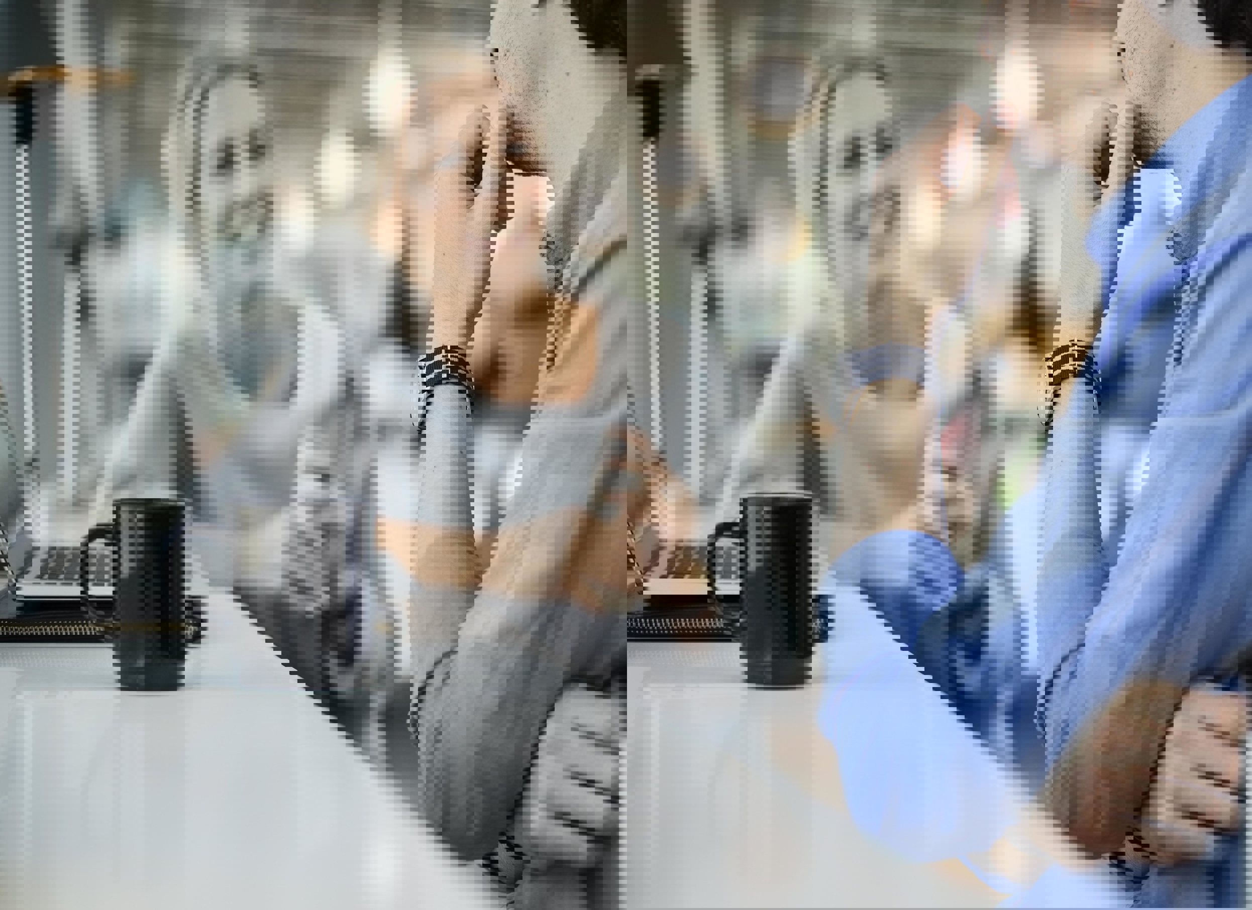 To kolleger i en positiv samtale over kaffe. Illustrerer en konstruktiv lønnssamtale med leder.