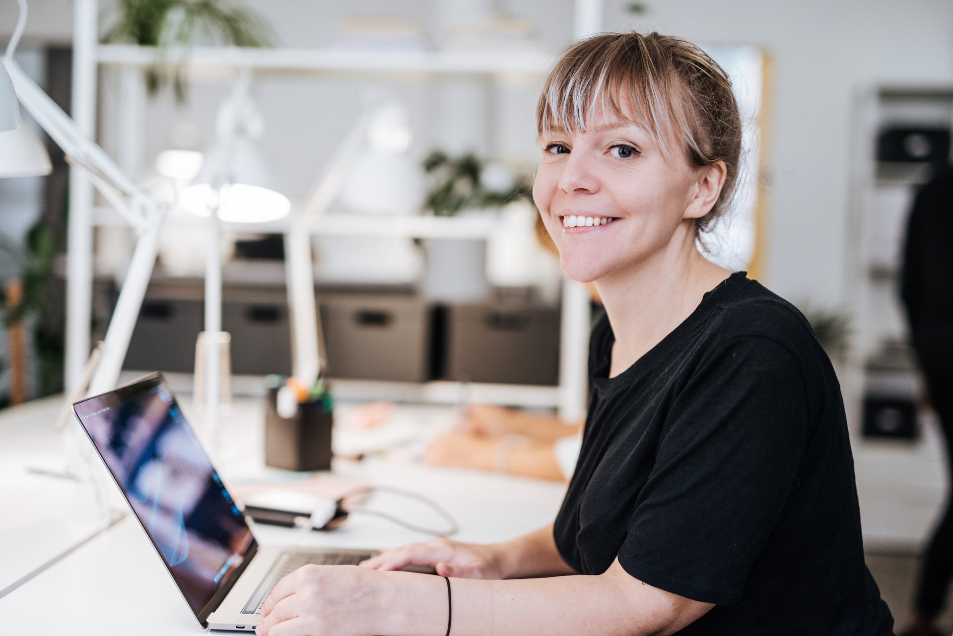 Person som arbeider ved en laptop i et kontormiljø