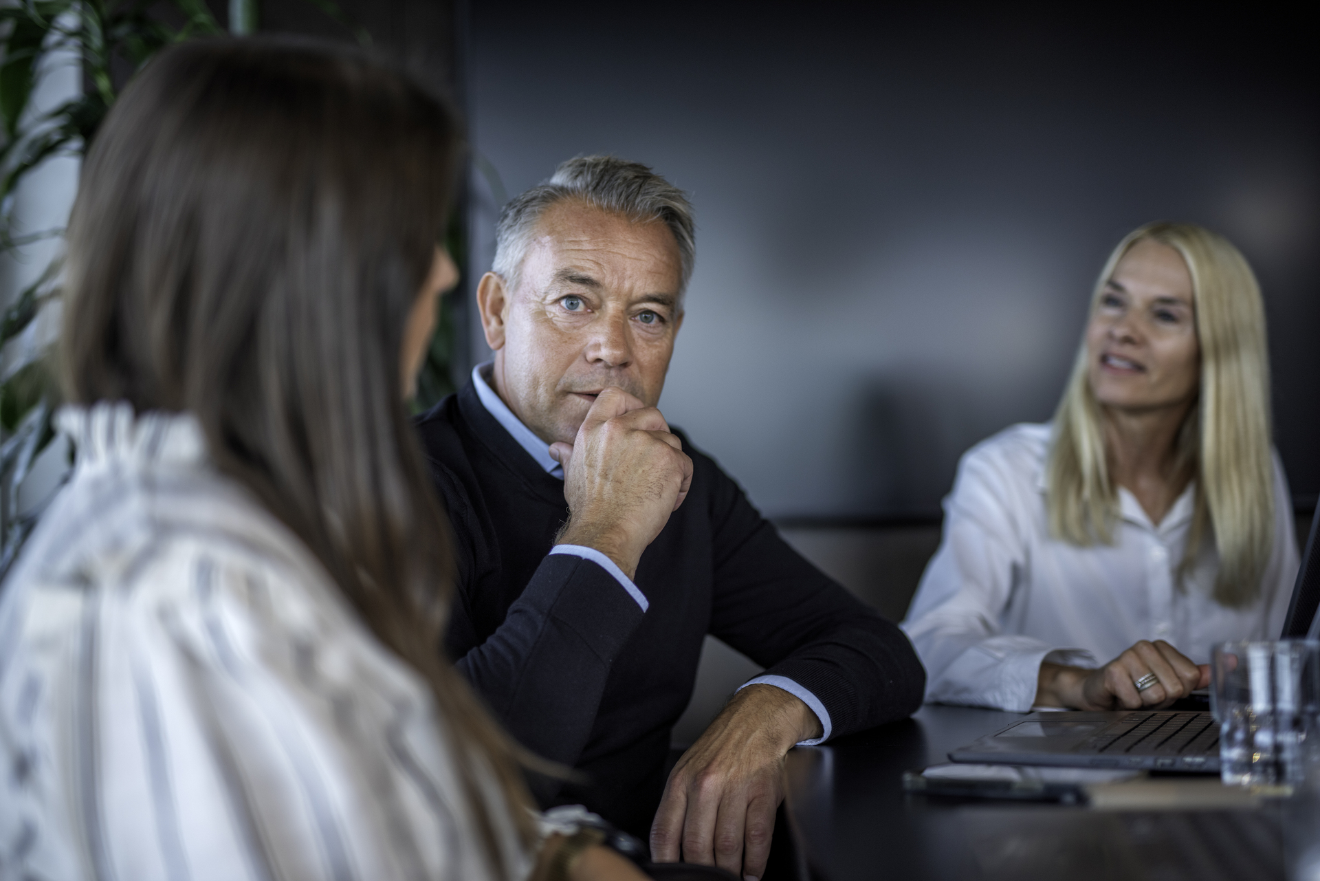 Three people in a meeting, representing a member in conversation with their union representative and another party, in connection with downsizing or restructuring.