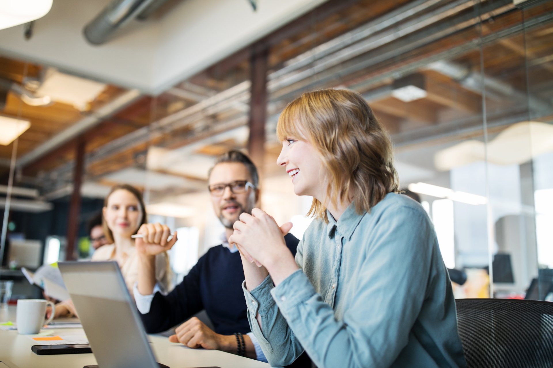 Three office workers in a discussion in a modern meeting room. Illustrates negotiations directly with the company.