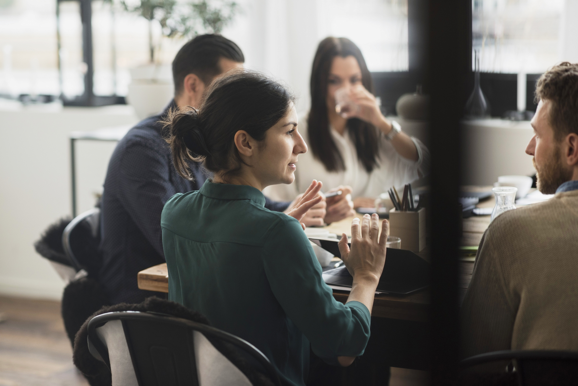 A group of people sit around a table in a discussion, symbolizing negotiations and cooperation around the conclusion of collective agreements and working conditions.