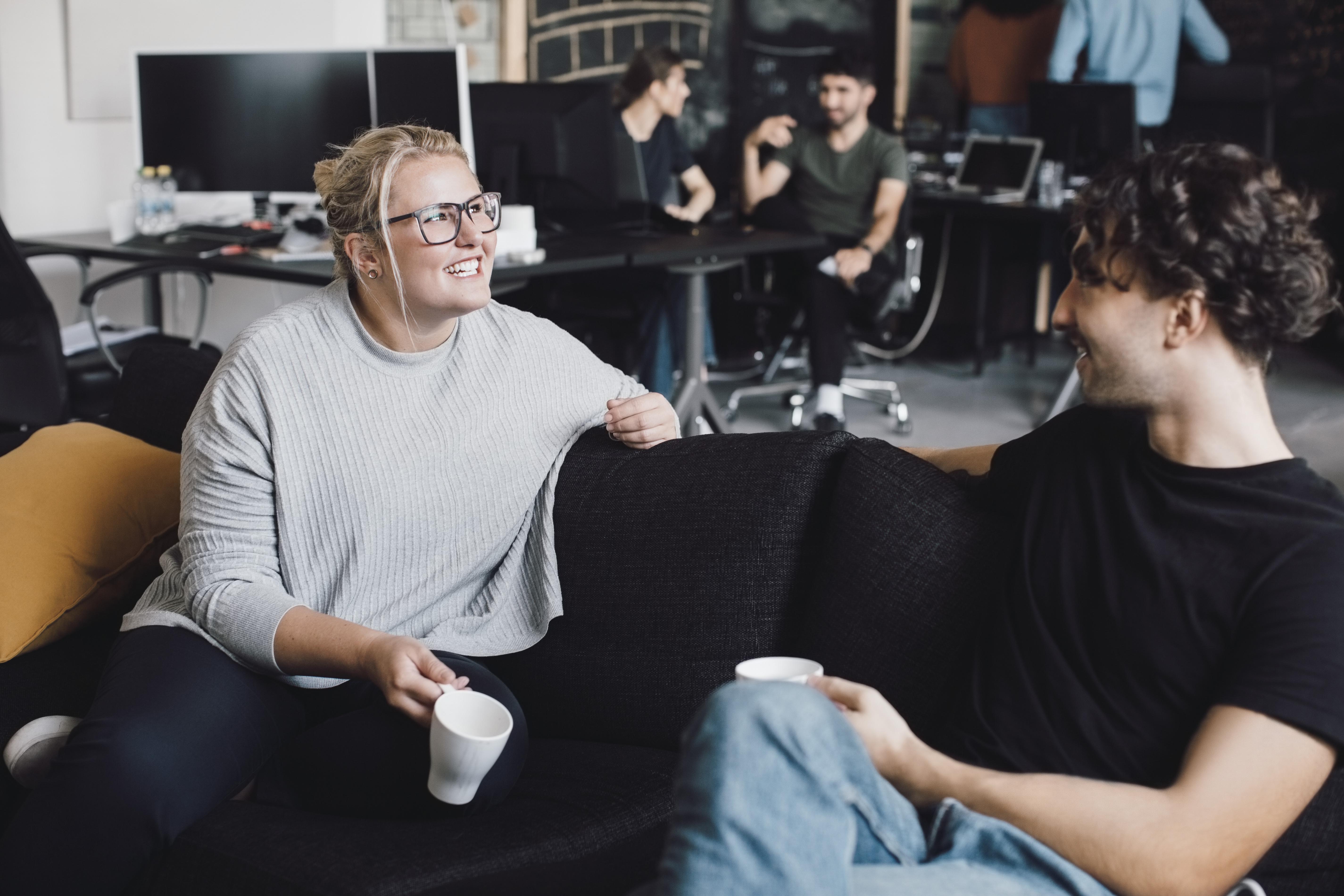 Smiling union representative in conversation with a member over a cup of coffee – committed union representative in everyday work.