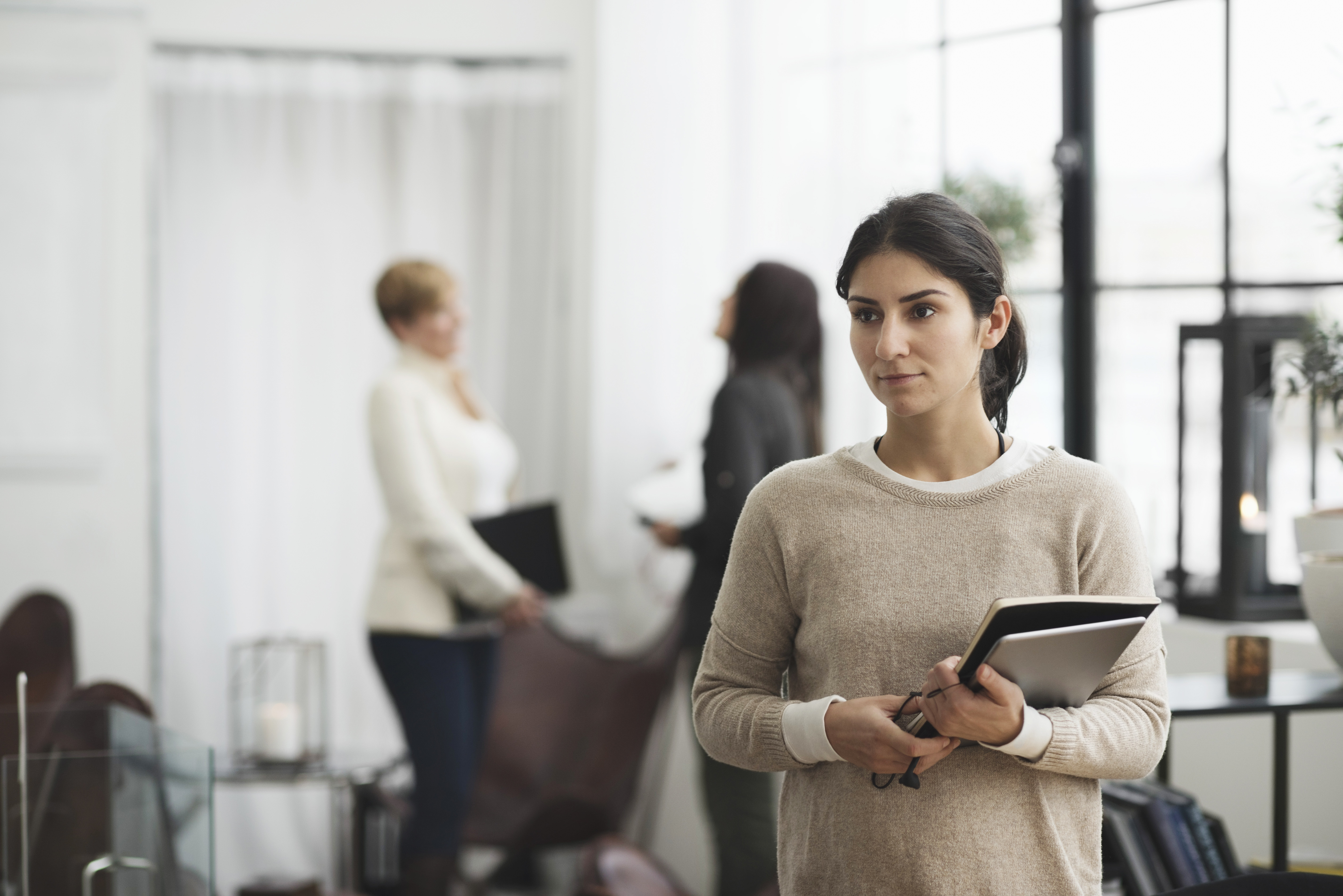 Young female engineer carrying papers and looking serious on her way to a discussion meeting before a possible dismissal