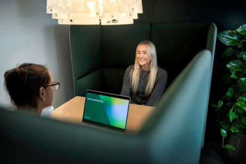 Two ladies sit on opposite sides of the table and talk