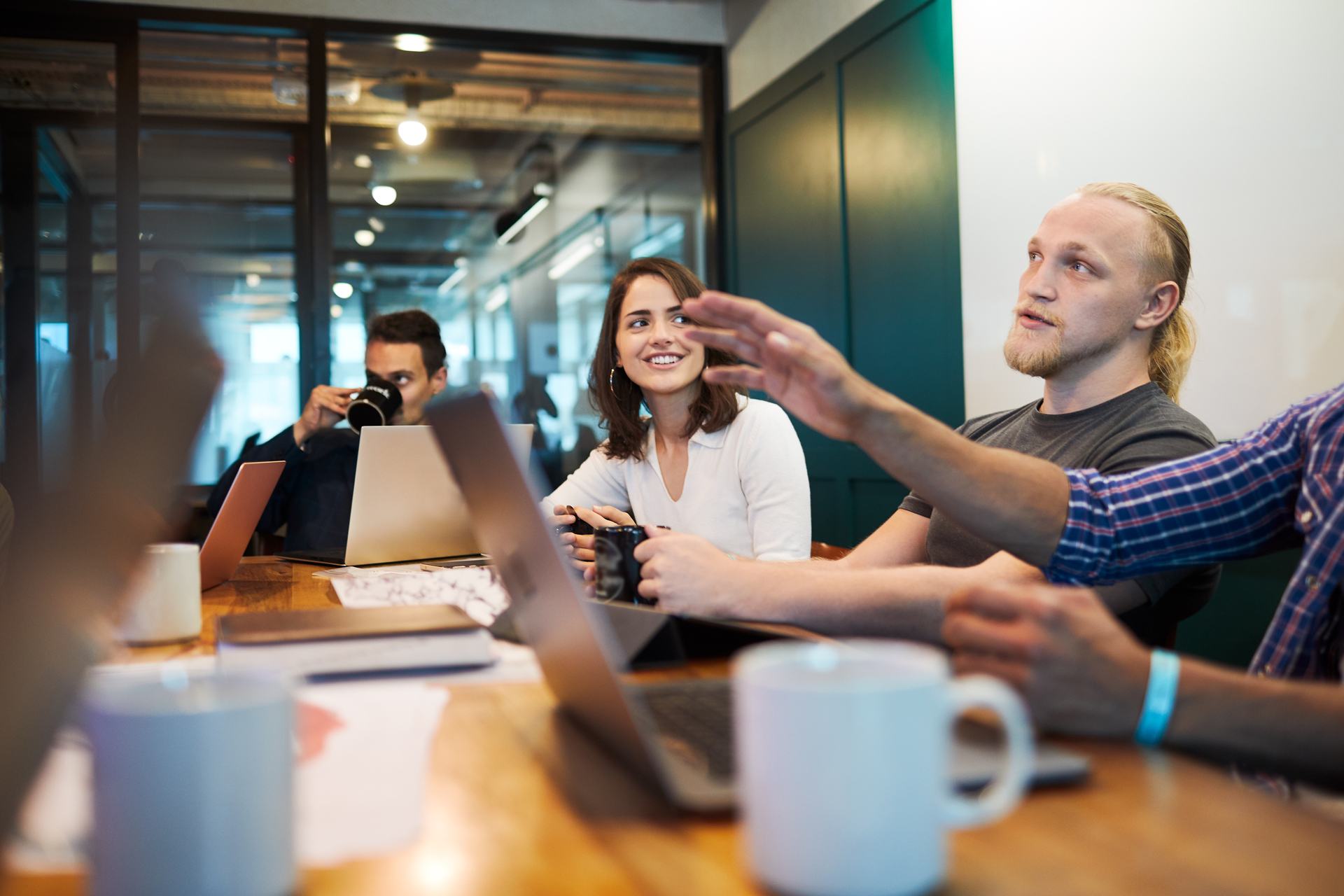 Two smiling business colleagues, a woman and a man, make a fist bump as a sign of agreement or success in an office environment. The picture illustrates positive cooperation and agreement, relevant to the process of entering into collective agreements.
