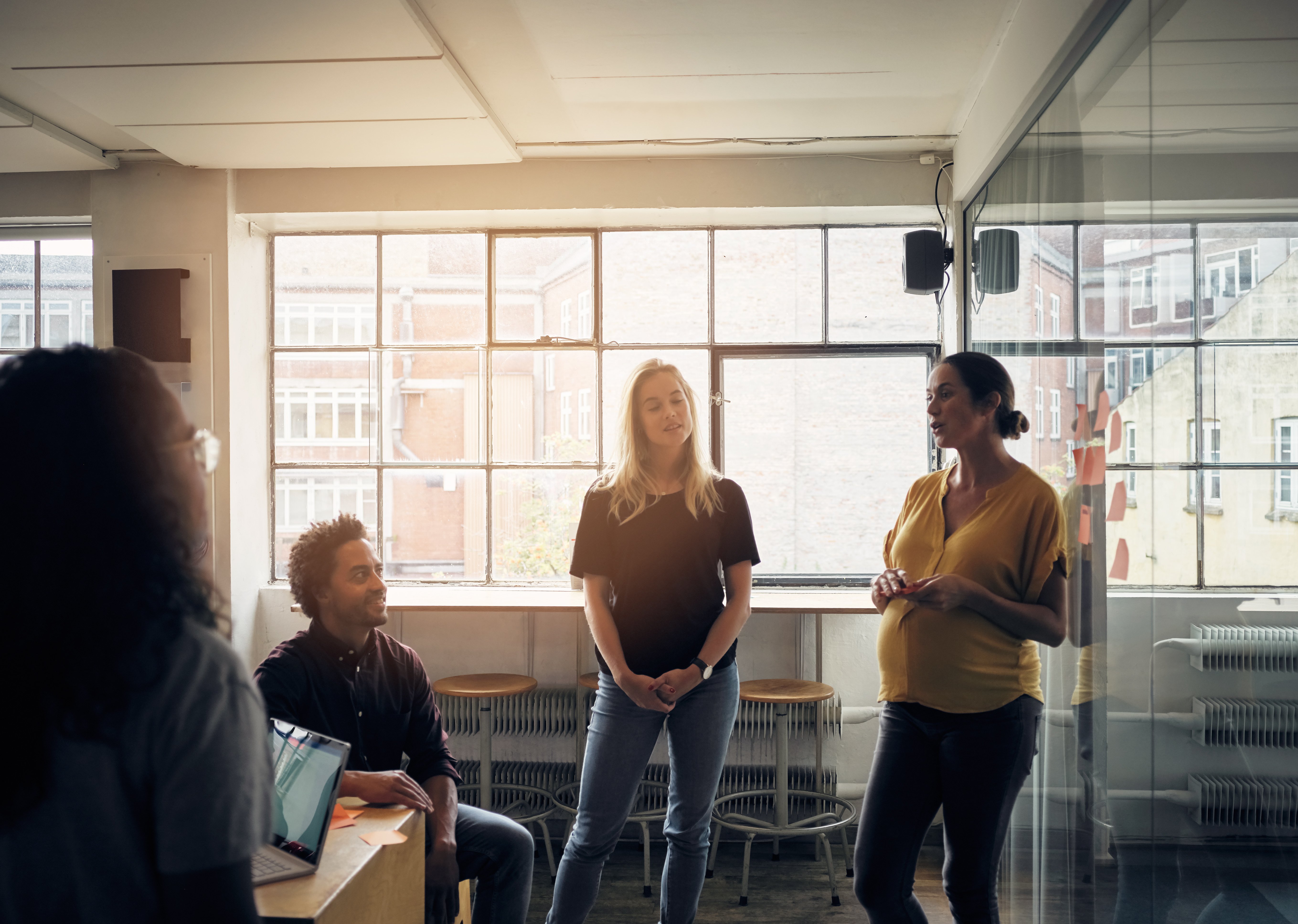 A pregnant woman presents to her colleagues at the workplace. Photo: GettyImages